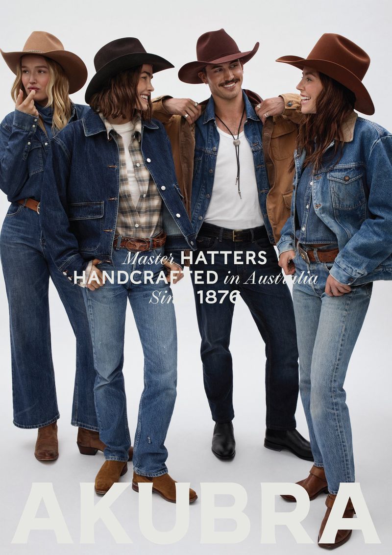 A group of four people wearing hats and denim jackets are posing in a studio shot. The image promotes a hat brand, Akubra.