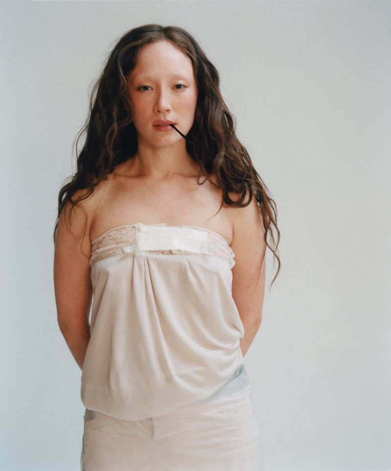 Havana Rose Liu posing in a strapless draped off-white top against a plain studio backdrop.