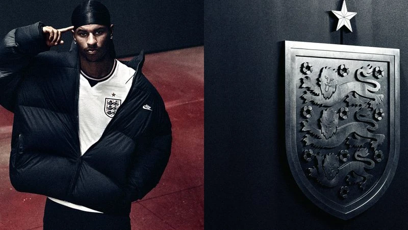 Marcus Rashford wearing an England football jersey and oversized black Nike puffer jacket next to a large Three Lions crest.