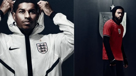 Marcus Rashford and another England athlete posing in Nike England soccer apparel against a dark studio backdrop.