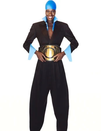 Model Awar Odhiang smiling in a black suit, blue swim cap, and large gold championship belt against a white studio background.