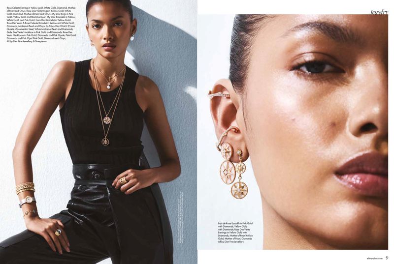 Fashion shot of a woman wearing a black top, black leather pants, and gold jewellery, including a necklace, rings, earrings and a watch.