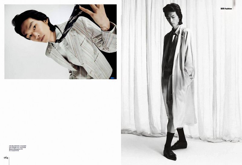 Editorial magazine spread of model Bai wearing a pinstripe suit and lightweight trench coat against sheer white curtains.