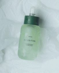 Gezeiten serum dropper bottle with a dark green cap set against a translucent white textured backdrop.