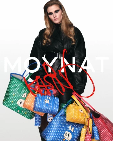 Model Lara Stone in a black leather coat holding an assortment of colourful patterned Moynat handbags against a white studio background.