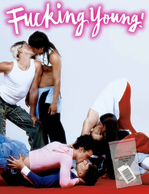 Multiple men kissing in a group setting on a red surface, with a magazine cover featuring the text 'Fucking Young!' in pink.