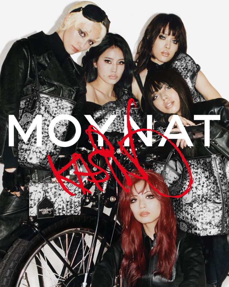 Five female models styled in black leather outerwear pose with patterned tote bags in front of a white seamless background.