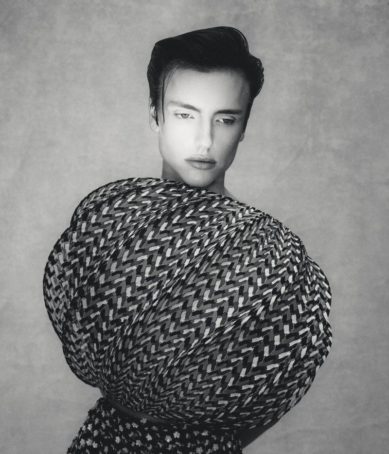 Model Charlie Jones in a voluminous spherical patterned top against a textured grey studio backdrop in black and white.