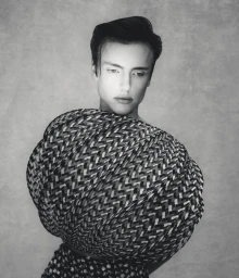 Model Charlie Jones in a voluminous spherical patterned top against a textured grey studio backdrop in black and white.