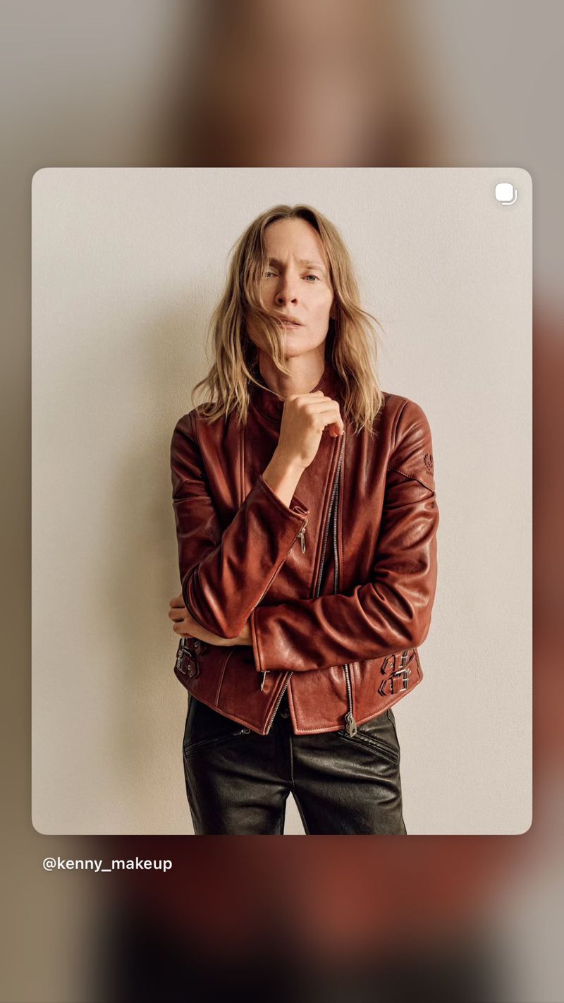 Model Lindsay Sullivan posing in a brown leather motorcycle jacket and black leather trousers against a pale background.
