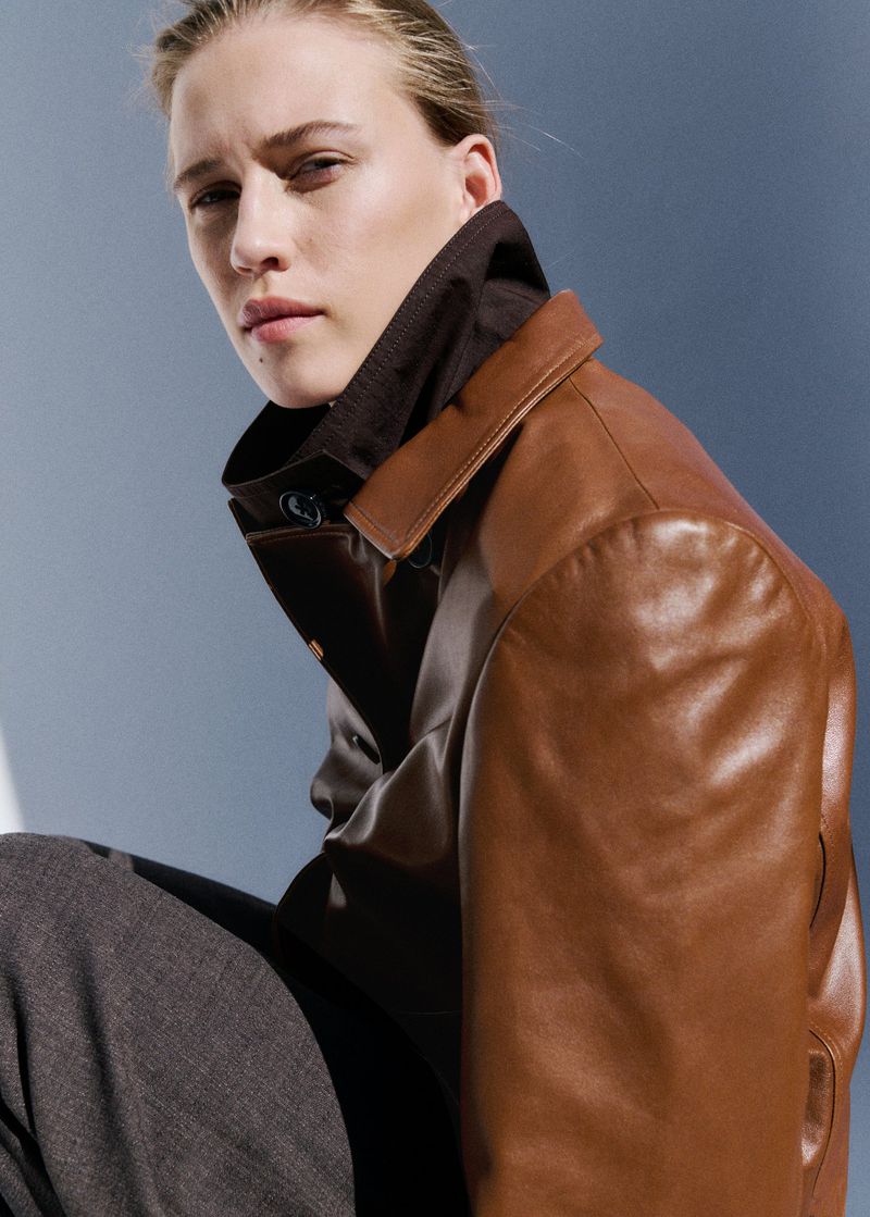 Model Liva Been wearing a brown leather jacket and high-collar top in a fashion portrait for Mango.