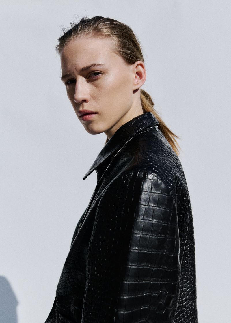 Model Liva Been wearing a black embossed leather jacket against a white studio background for Mango