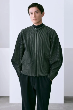 A stylish Asian man in a black turtleneck and striped jacket poses confidently against a white background in a studio setting.