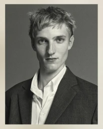 Monochrome portrait of Pierrick Grégoire wearing a tailored dark blazer and open white shirt for The Row Spring 2026.