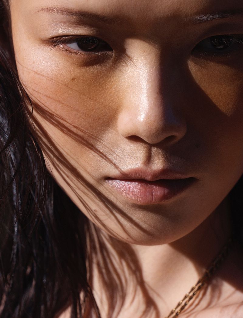 Close-up portrait of model Xie Chaoyu with dark hair and striking lighting for Vogue Thailand