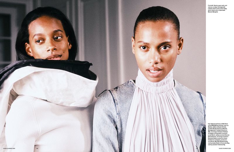 Two Black models, Wendy Garcia and Cailane Oliveira, posing in high-neck designer tops and a denim jacket for a fashion editorial.