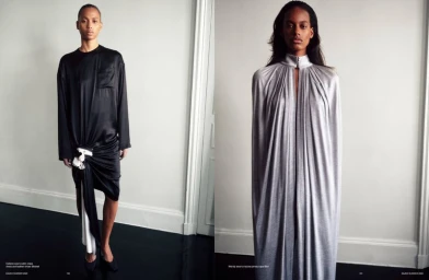 Two fashion models posing side by side in a minimalist interior with white walls and a dark glossy floor.