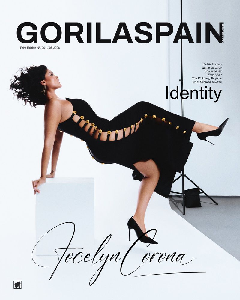Model Jocelyn Corona wearing a black dress with gold buttons for a GORILASPAIN magazine cover shoot in a studio.