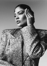 Model Jocelyn Corona wearing a structured textured metallic blazer with wide shoulders in a black and white fashion portrait.