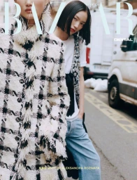 Two models posing on an urban street, one in a fringed black-and-white tweed coat and the other in a beaded vest with denim jeans.