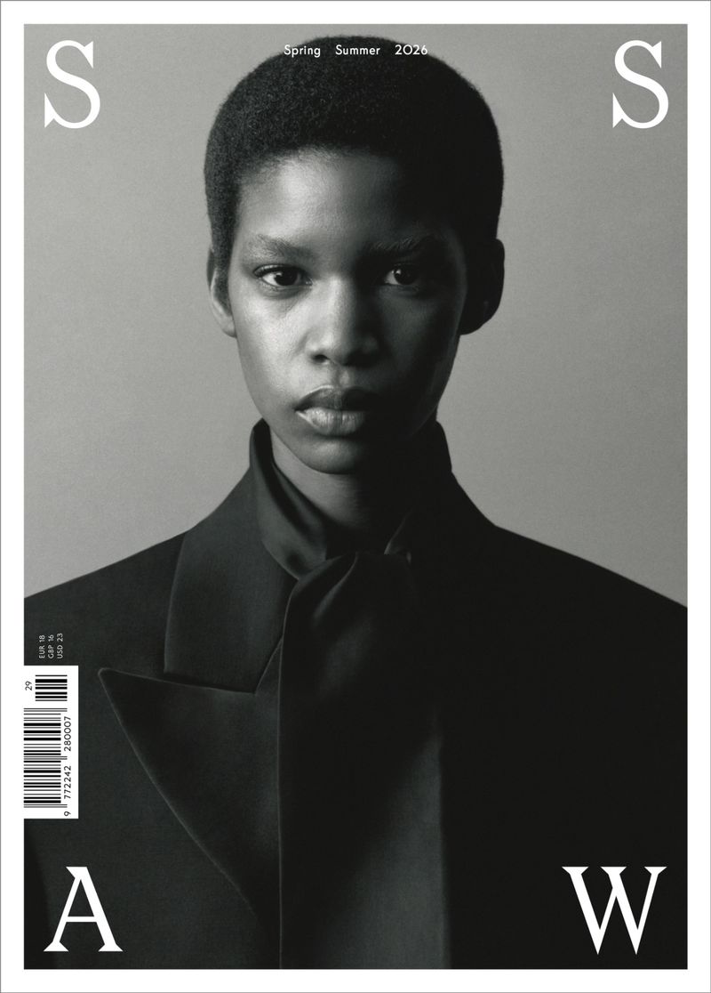 Black and white magazine cover featuring a close-up portrait of a Black woman with short hair wearing a black tailored blazer.