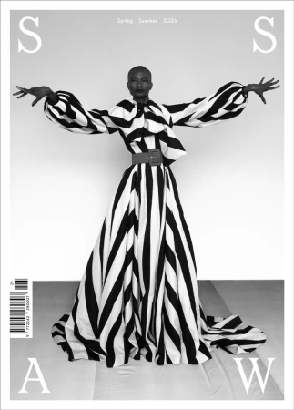 Model Debra Shaw posing with outstretched arms in a dramatic black and white striped gown for a magazine cover.