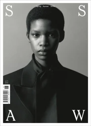 Black and white magazine cover featuring a close-up portrait of a Black woman with short hair wearing a black tailored blazer.
