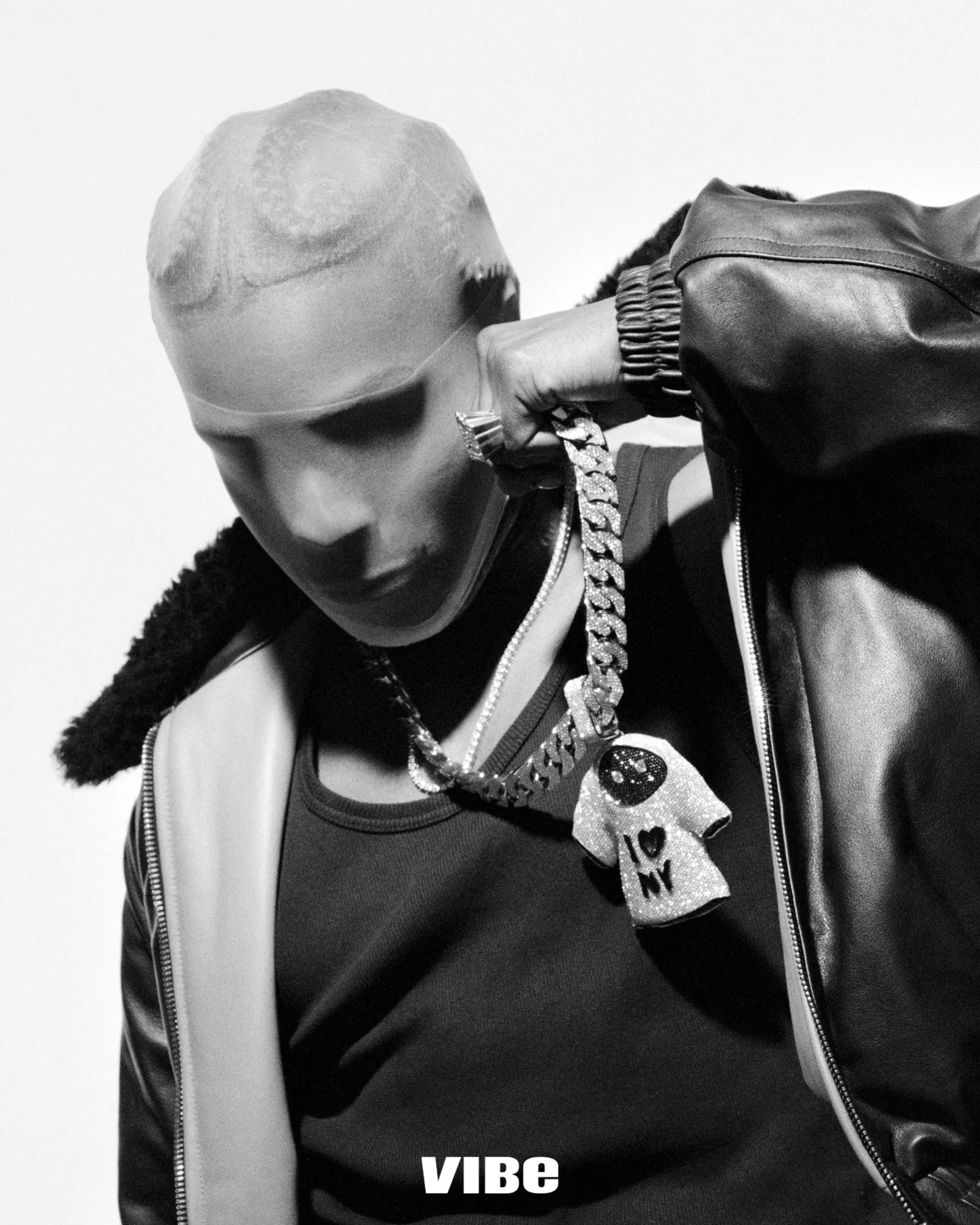A$AP Rocky wearing a sheer stocking over his head, leather jacket, and diamond chain necklace with an I Love NY pendant.