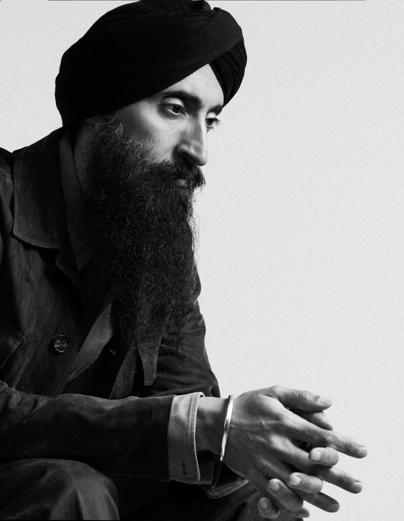 Monochrome portrait of Waris Ahluwalia wearing a dark turban and jacket against a plain background