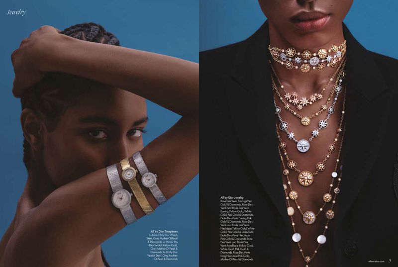 Editorial spread of a model wearing stacked luxury watches on her arm and layered gold and diamond star necklaces over a black blazer.