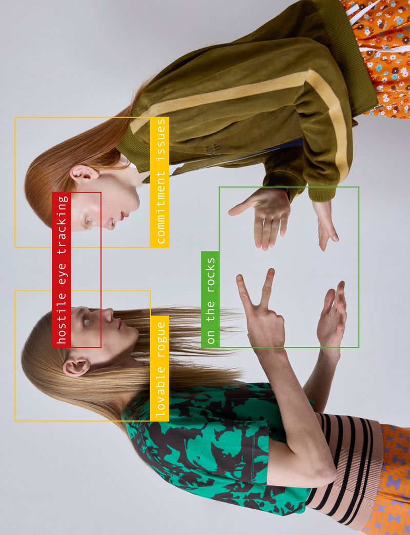 Two fashion models facing each other surrounded by colourful graphic computer-vision tracking boxes against a grey background.