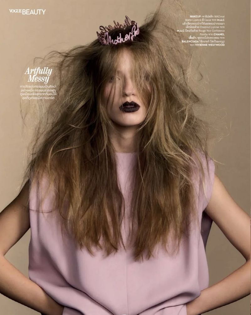 Model Carolina Mendillo with teased messy hair, dark lipstick, and a pink sleeveless top for Vogue Thailand.