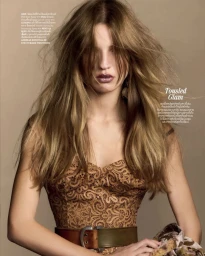 Model Carolina Mendillo with voluminous tousled hair wearing an ornate patterned corset and wide belt for Vogue Thailand editorial.