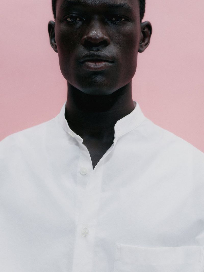 Gabriel Nhial in a white collared shirt against a plain pink background for Arket