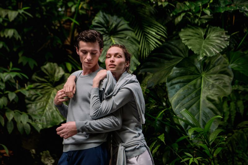 Two models posing together against a lush green tropical forest background for Falconeri