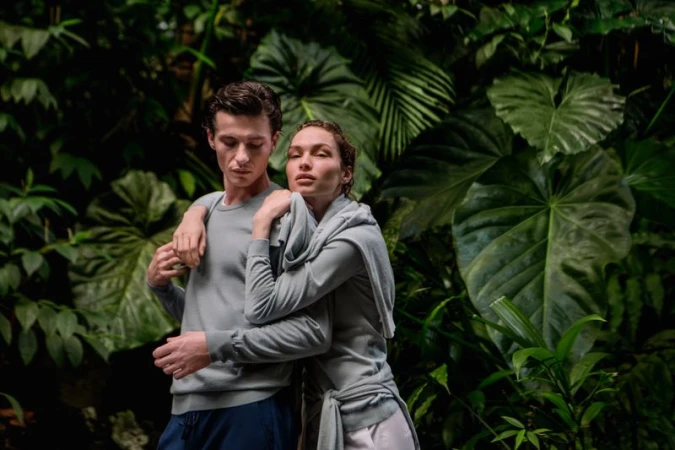 Two models posing together against a lush green tropical forest background for Falconeri