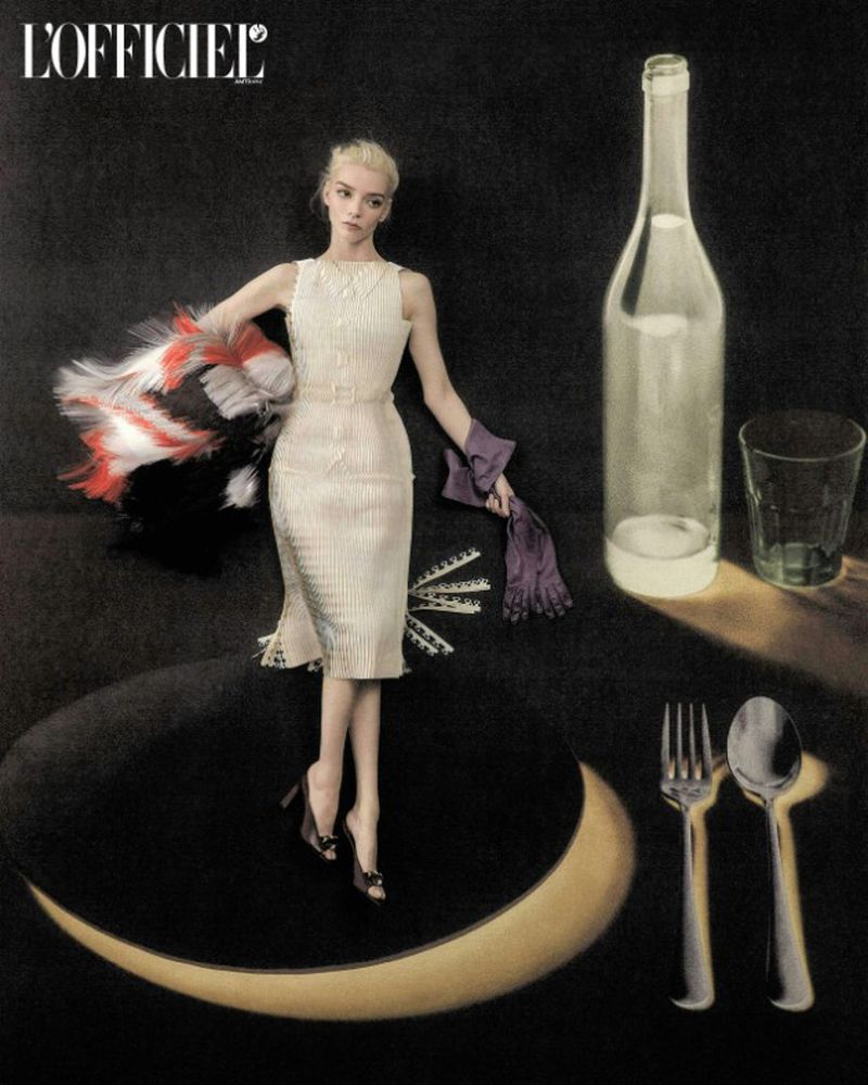 Anya Taylor-Joy in an off-white dress posing atop a plate beside an oversized glass bottle and cutlery.