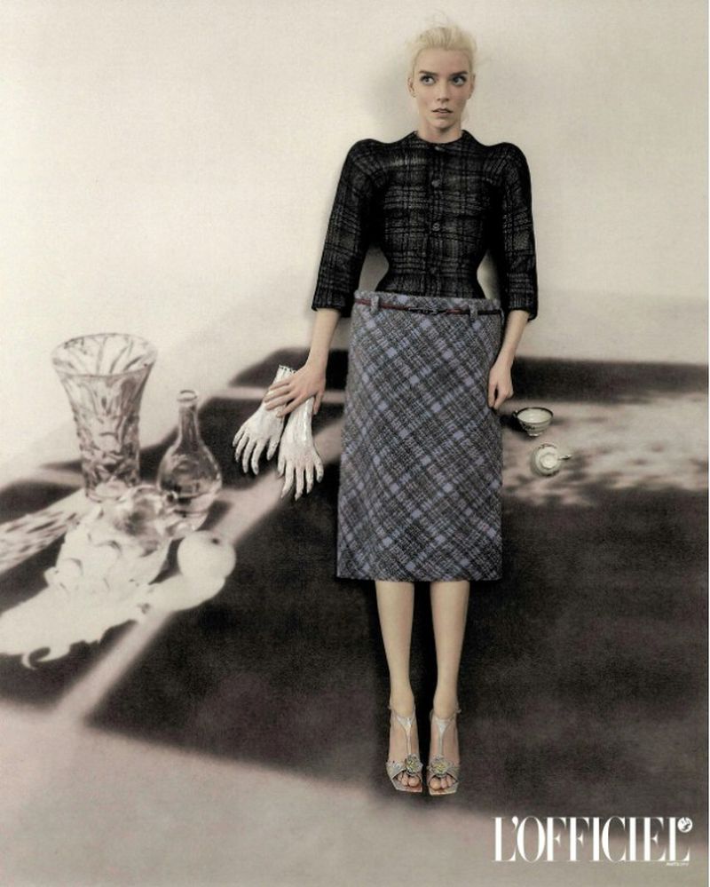 Anya Taylor-Joy in a dark plaid jacket and grey plaid skirt integrated into a surreal tabletop still life for L'Officiel Italia.