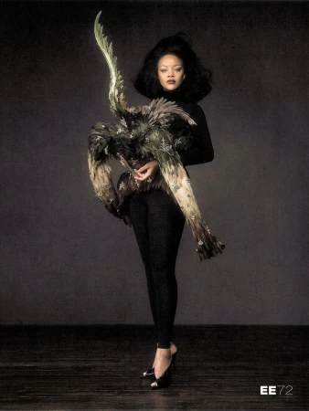 Rihanna wearing an elaborate feathered avian sculpture and black clothing in a studio portrait by Szilveszter Mako.