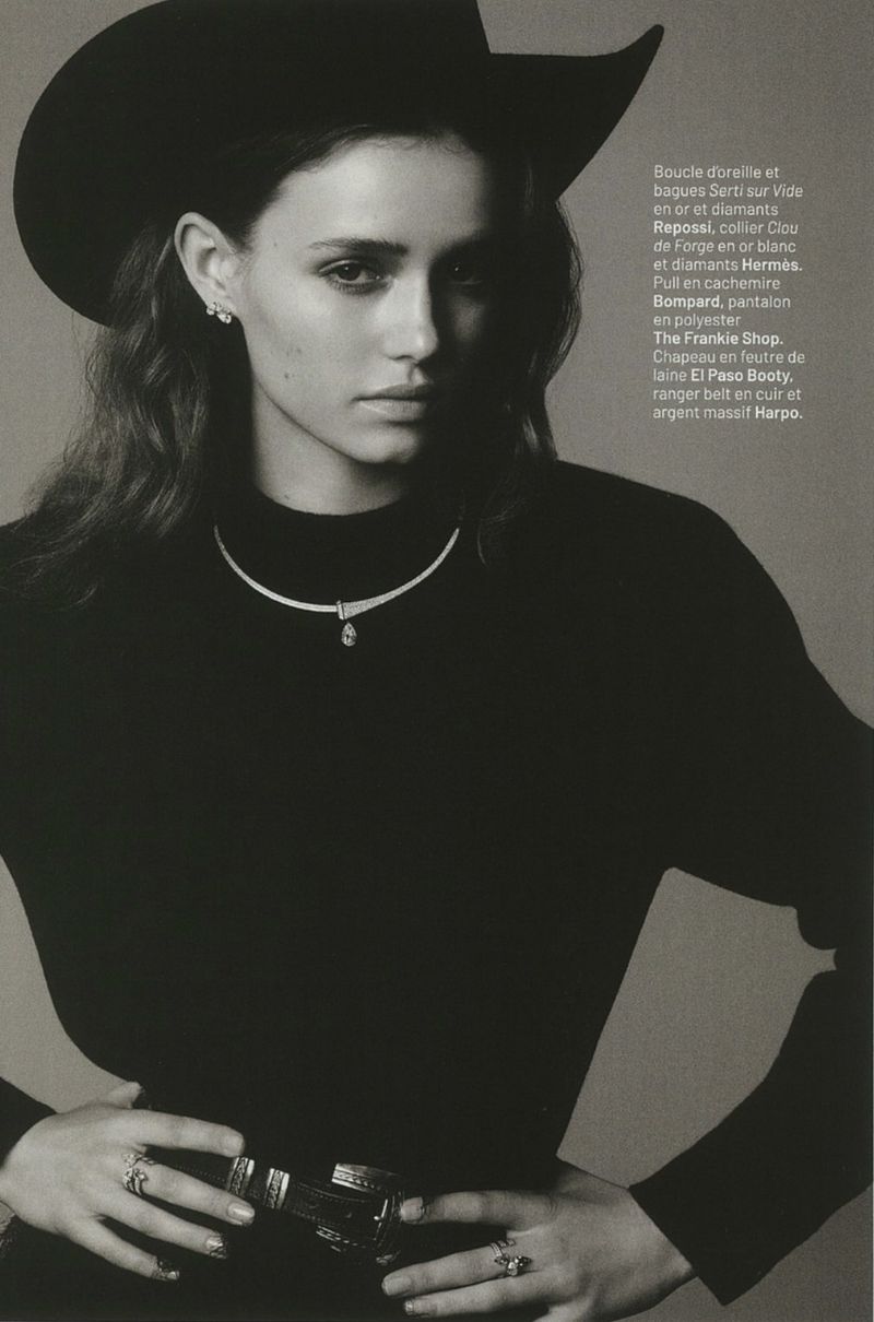 Model Floor Vrins posing in a black cowboy hat and turtleneck sweater with fine jewelry against a neutral studio backdrop.