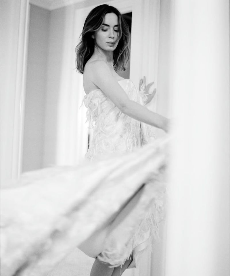 Black and white portrait of actress Emily Blunt in a textured strapless gown with a dynamic motion blur foreground.