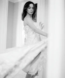 Black and white portrait of actress Emily Blunt in a textured strapless gown with a dynamic motion blur foreground.