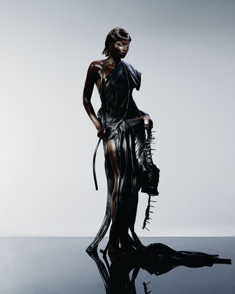 Model Puck Loomans in a sculpted black draped gown on a reflective studio floor for Glamcult Magazine.