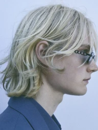 Close-up profile of blonde model Leander Straub wearing Gucci sunglasses and a blue jacket for ICON Magazine Italy.