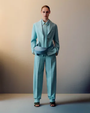 Model Dalton Dubois standing in a light blue tailored pantsuit with a matching waist bag for JOSEPH Spring Summer 2026.
