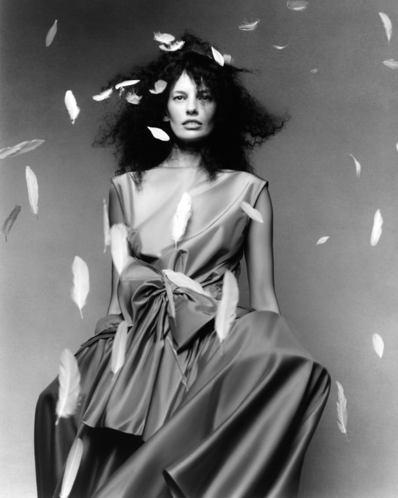 Model Amanda Murphy in a silk gown surrounded by floating white feathers for Vogue Portugal shot by Mario Kroes