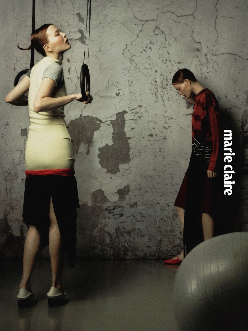 Fashion model holding gymnastics rings alongside another model in a distressed concrete room for Marie Claire Taiwan editorial.