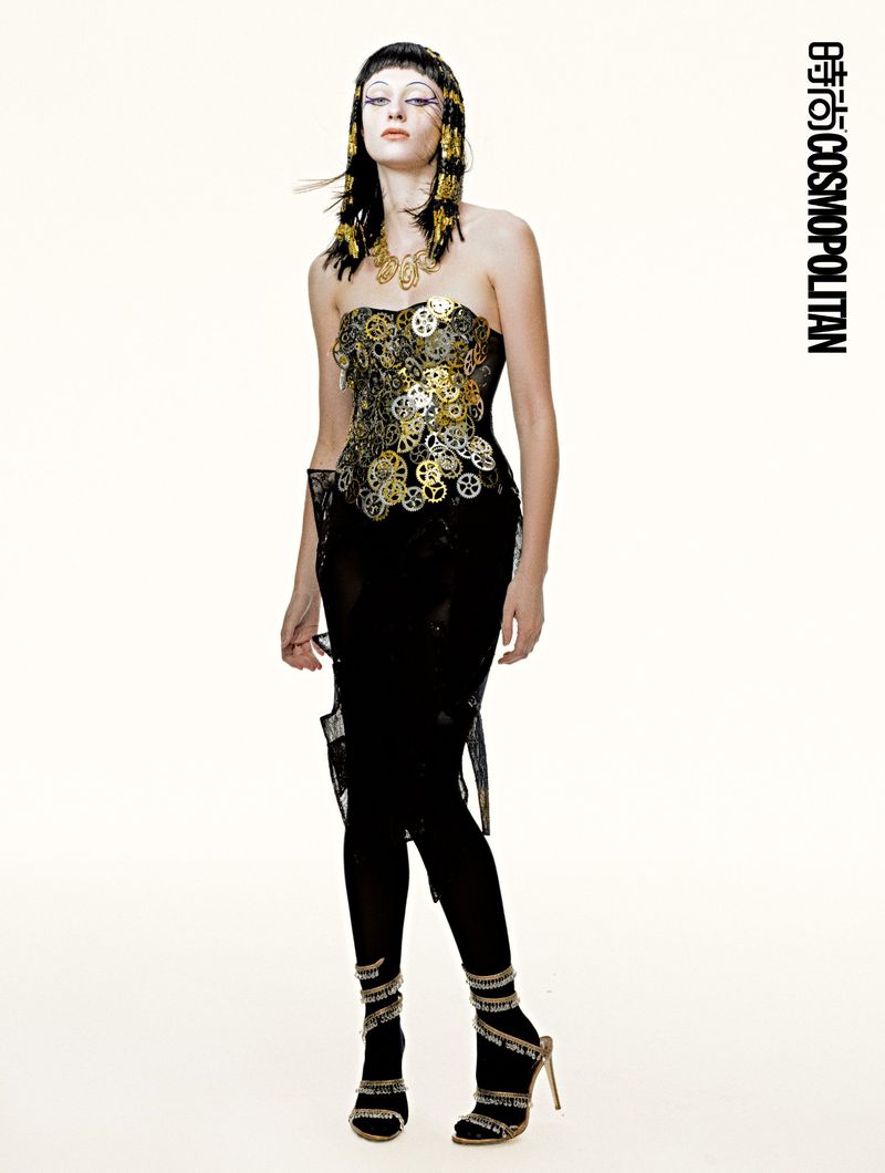 Model Hannah Vincent posing in a black strapless embellished dress and metallic stiletto heels against a white studio background.