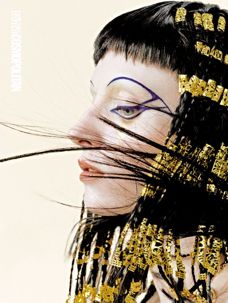 Profile close-up of model Hannah Vincent featuring graphic eyeliner and black braided hair adorned with gold cuffs.