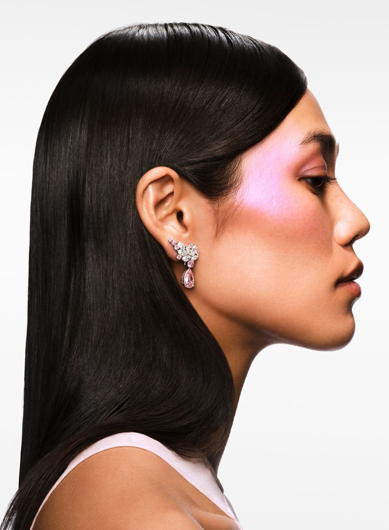 Model Jade Nguyen in profile wearing a Bulgari diamond and pink gemstone drop earring against a white background.